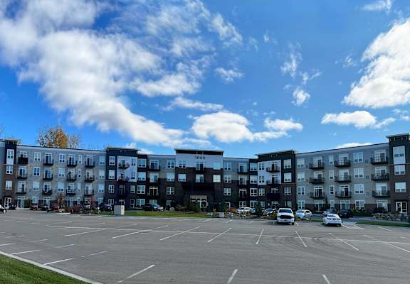 an empty parking lot in front of an apartment building