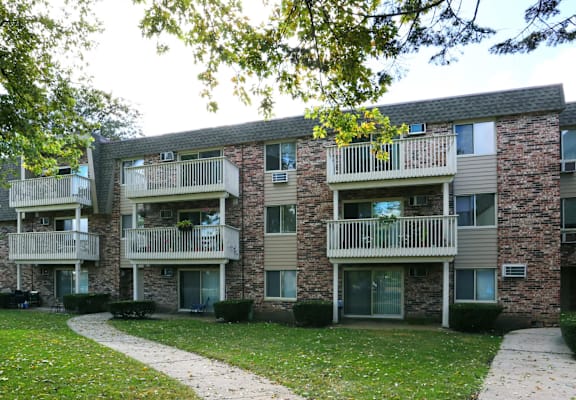 an apartment building with balconies and a sidewalk