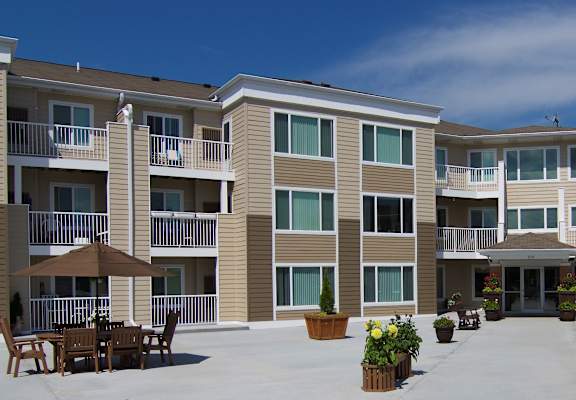 Front of Centennial Hill with a patio and a lot of windows.