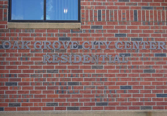 A brick building with a sign that says Oak Grove City Center Residential.