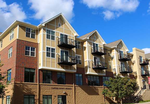A large apartment building with balconies and a red brick facade.
