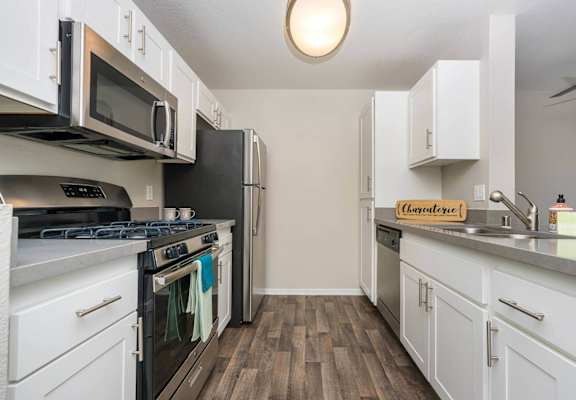 a kitchen with stainless steel appliances and white cabinets