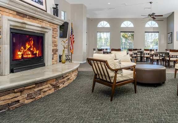 a living room with a fireplace and a table and chairs