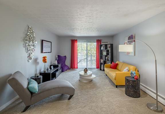a living room with a yellow couch and a chair and a table