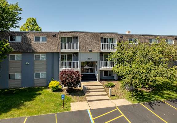 front view of an apartment building with sidewalks and grass