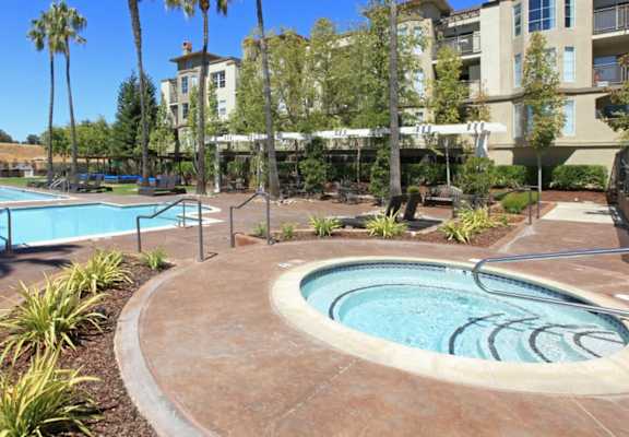 a resort style pool with a hot tub and jacuzzi