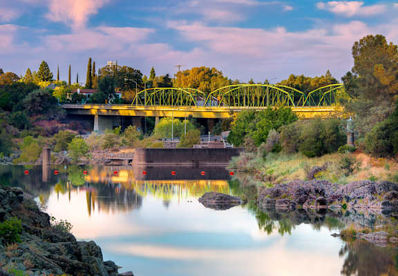 a bridge over a river with trees in the background