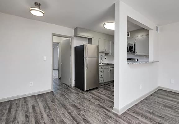 A kitchen with a refrigerator, microwave, and oven.