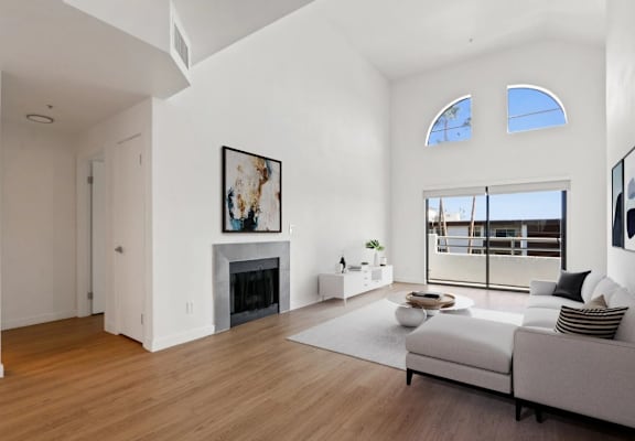 A modern living room with a fireplace and a large window.