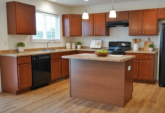 A kitchen with wooden cabinets and a black refrigerator.