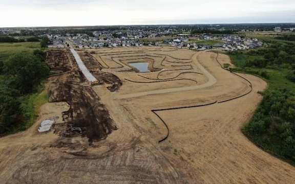 an aerial view of a construction site with a town in the background