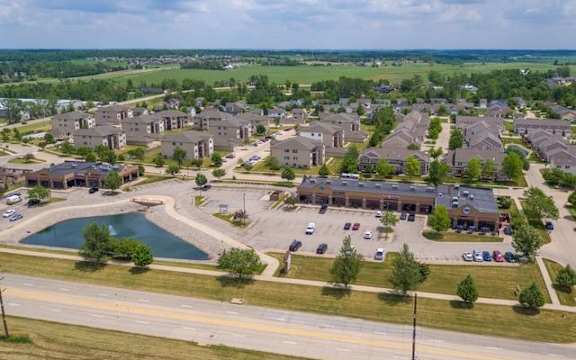 an aerial view of a community with a lake and parking lot