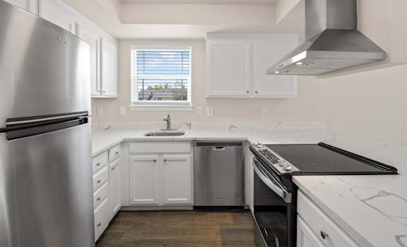a small kitchen with white cabinets and stainless steel appliances