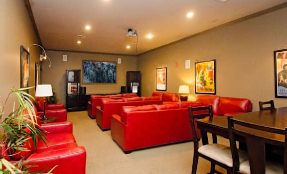 theater room with red couches and dining tables