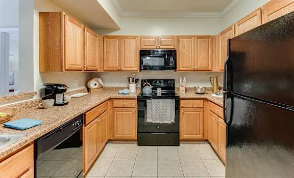 a kitchen with wooden cabinets and black appliances