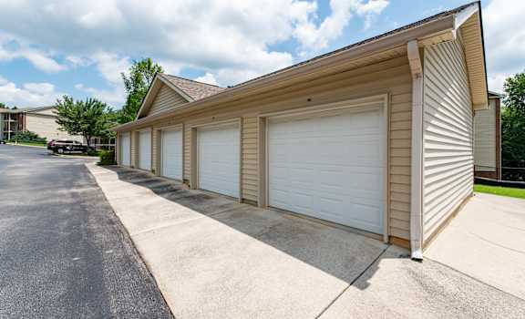 A two-car garage with a brown siding and white garage doors.