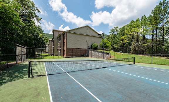 A tennis court with a building in the background.
