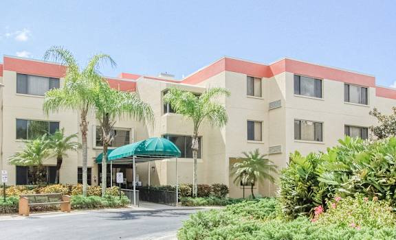 exterior of Villa San Carlos Senior Apartments with lush landscaping