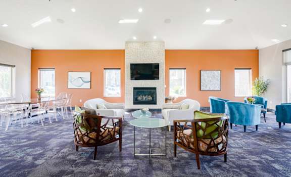 clubhouse room filled with furniture and a fire place in the back