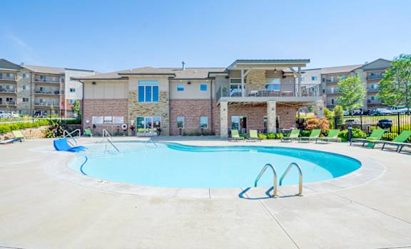 our resort style swimming pool with green lounge chairs