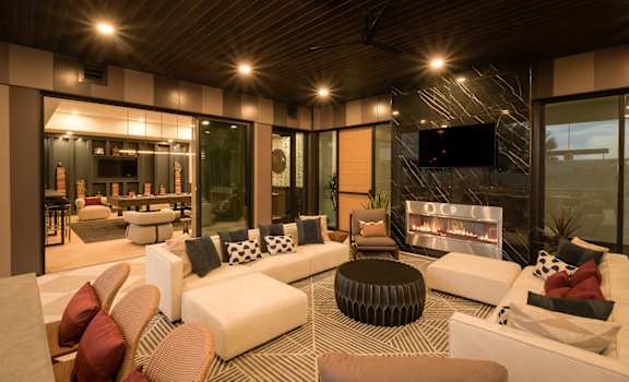 A modern clubhouse with a fireplace and a flat screen TV.