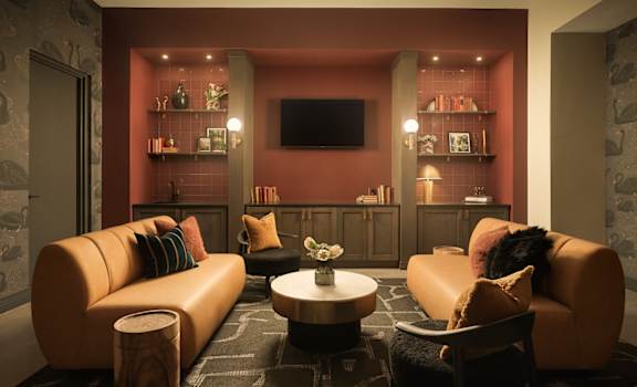 A room with a sofa, a chair, a coffee table, and a television.