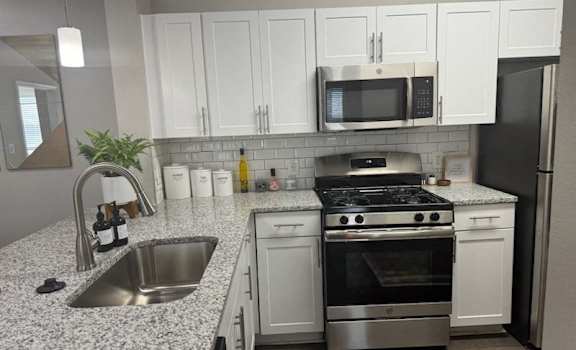 a kitchen with stainless steel appliances and granite counter tops