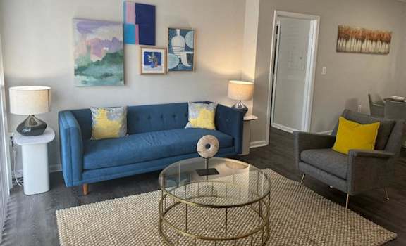 a living room with a blue couch and a glass table