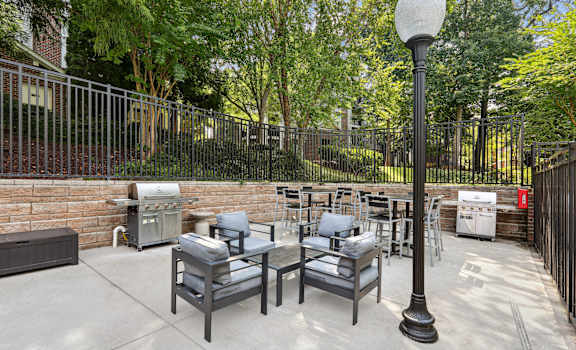 a patio with a table and chairs in front of a brick wall