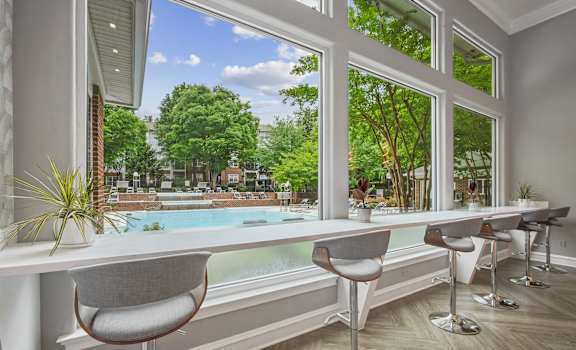 a dining room with a large window overlooking a pool