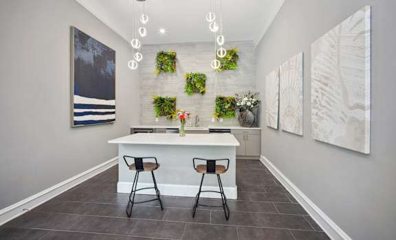 a kitchen with a white counter and three stools