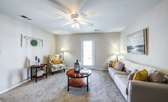a living room with a ceiling fan and a couch