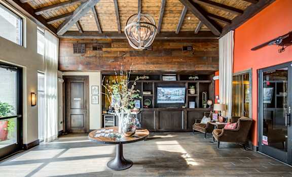 a living room with a table and chairs and a tv at Aviator West 7th, Fort Worth