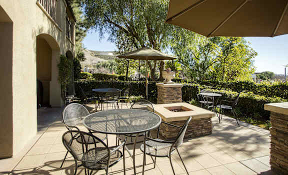 a patio with a table and chairs and a fire pit at 55+ Remington at Ladera Ranch, Ladera Ranch, CA