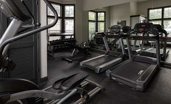 a gym with cardio equipment and weights in a building