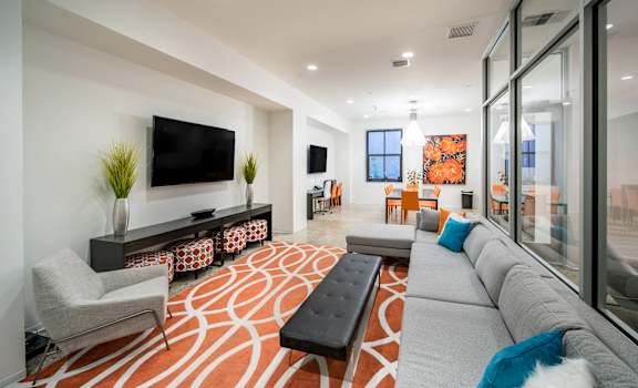 a living room with a gray couch and a television at The Equitable Building, Des Moines, IA, 50309