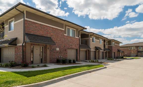 Charming brick townhome exterior with landscaped surroundings.