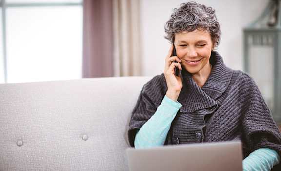 Stock Photo of Woman on Phone and Laptop