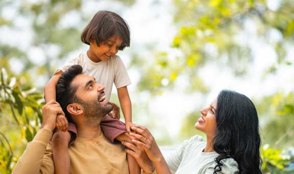 A family of three is enjoying a moment together outdoors.