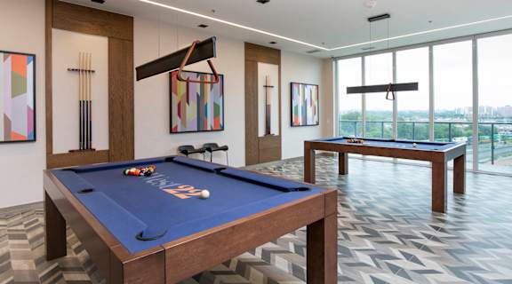 a games room with two pool tables and a ping pong table