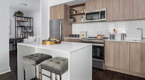a kitchen with wood cabinets and a white island with two stools