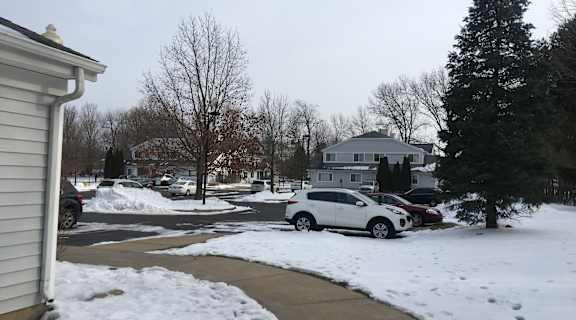 A white car is parked on a snowy street.