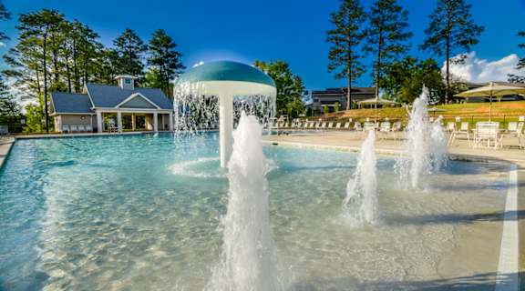 A pool with a fountain in the middle of it.