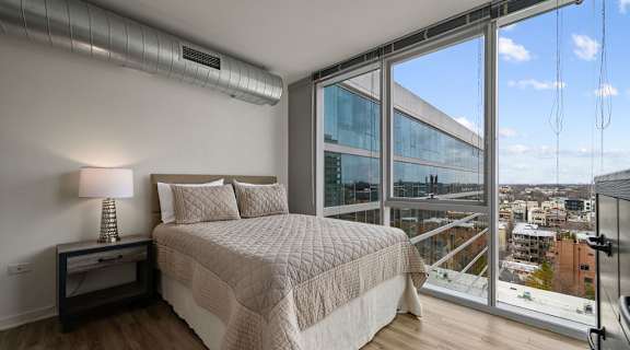 a bedroom with a large bed and a large window at Halsted Flats Apartments, Chicago, IL, 60613