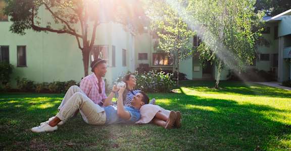 a man and two women sitting on the grass under a sprinkler  at Chase Knolls, Sherman Oaks, CA, 91423