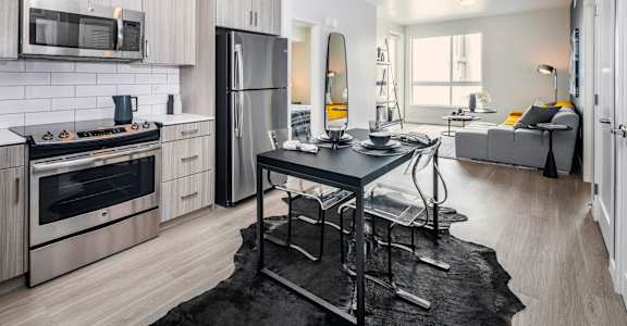 a kitchen with stainless steel appliances and a table at OLiVE DTLA in Los Angeles, California