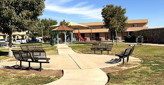 A park with a playground and benches.