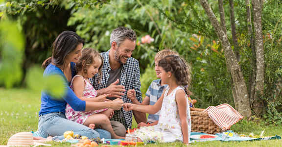 A family is having a picnic in a green park.