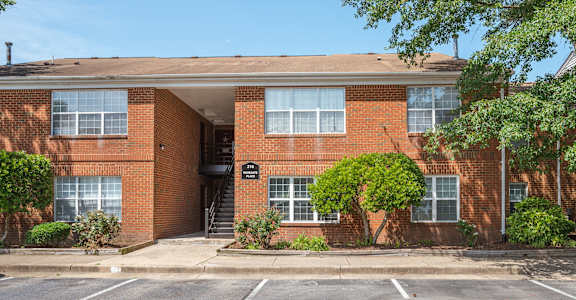a red brick apartment building with a parking lot