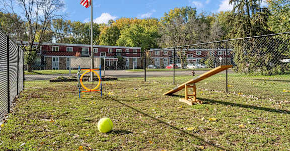 A playground with a yellow ball and a seesaw.